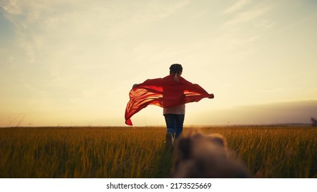 girl superhero. child in a red raincoat runs with a dog outdoors in the park. happy family kid lifestyle dream concept. little girl superhero runs with a dog across the field in nature - Shutterstock ID 2173525669