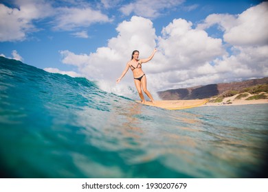 girl surfing in water in Hawaii