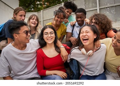A girl surrounded by classmates looking at a smiling camera. Happy students in high school.