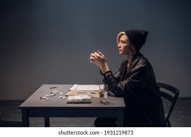 A Girl Suspected Of Distributing Drugs Sits At A Table In An Interrogation Room.