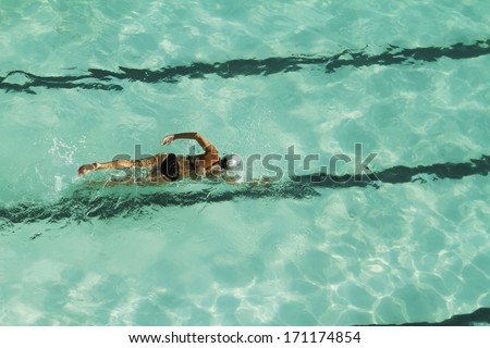 Girl swimming laps in a pool overhead view horizontal