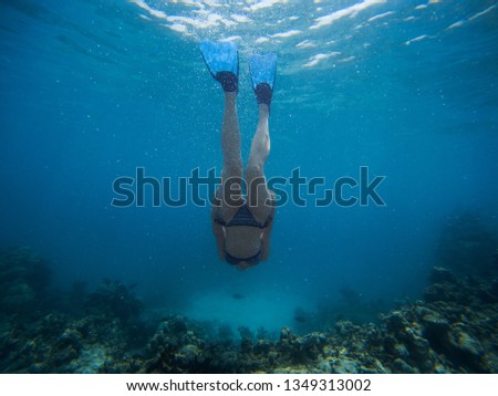 Girl swimming underwater near the coral reef