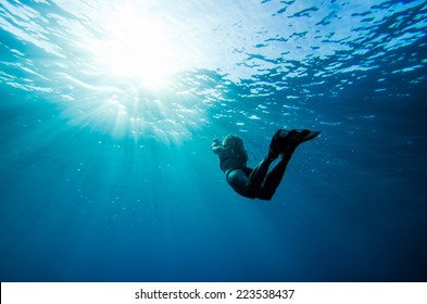 Girl Swimming Underwater With Sun Rays