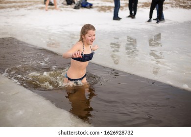 girl swims in icy water. wrinkling in winter. bathe in the mud. girl and ice on the river