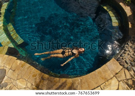 girl swims in the pool view from above