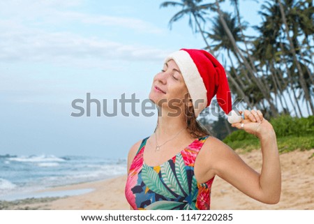 A girl in a swimsuit and Santa's hat on the ocean