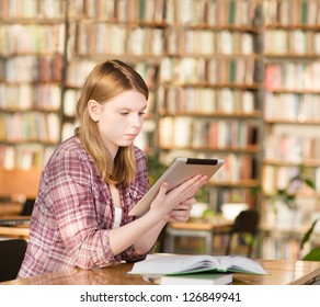 girl with tablet computer in library