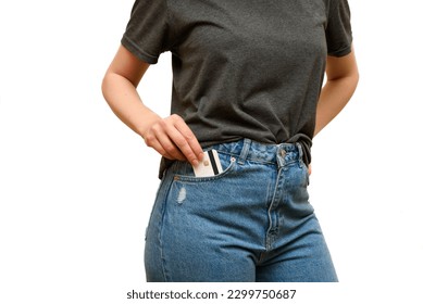 Girl take credit card from pocket jeans pants. Woman's is wearing blue jeans and gray t-shirt. Casual wear. Shopping trip. Payment for purchases by credit card. 