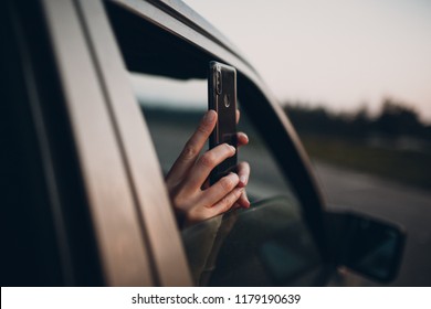 Girl takes pictures on the phone from the car window - Powered by Shutterstock