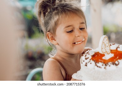 Girl taking a bite on birthday cake. Birthday cake. little girl biting birthday cake