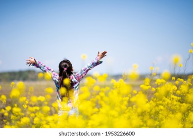 girl taking a deep breath in a flower field