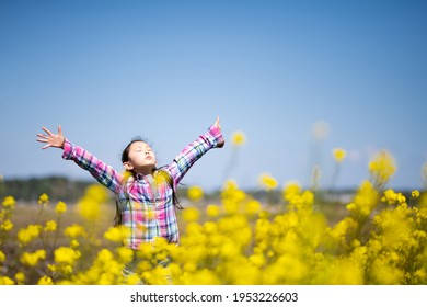 Girl Taking A Deep Breath In A Flower Field