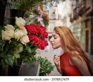 Girl Taking Off Mask And Smelling Flowers