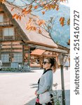 Girl taking photos at the ancient village of Shirakawago in Japan.