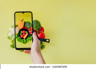 Girl taking picture of vegetarian food on table with her smartphone. Vegan and healthy concept - Powered by Shutterstock