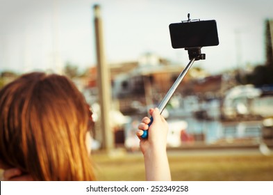girl taking selfie picture outdoors.Focus on phone