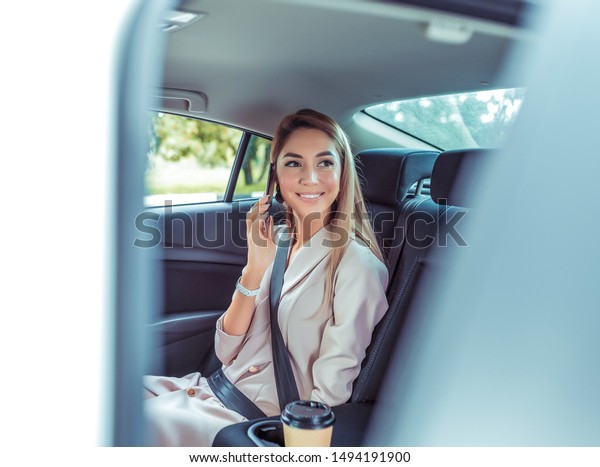 girl talking on phone, summer city taxi, sitting\
car, door opens, smiling happily, meeting her friend car, pleasure\
of traveling city taxi. A cup coffee, long hair formal suit, a\
business lady
