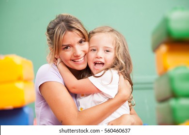 Girl and teacher playing in kindergarten