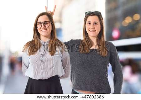 Girl teasing her sister on unfocused background