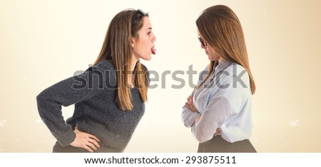 girl teasing his sister over ocher background  