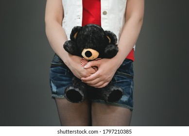 Girl With Teddy Bear In Hands Close Up On The Gray Background.