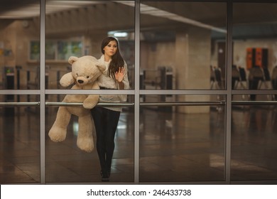 Girl With Teddy Bear In His Hands Waving Goodbye Hand, It Is Very Sad.