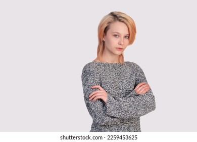 girl teenager in a closed position looks into the frame isolated on a light background - Shutterstock ID 2259453625