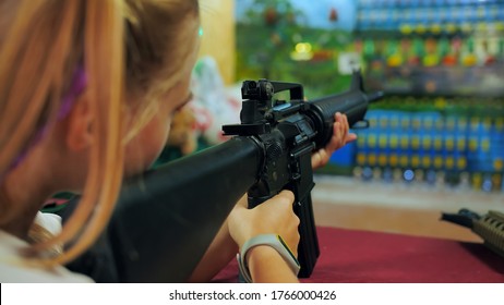 Girl teenager with a gun shoots at a shooting range.