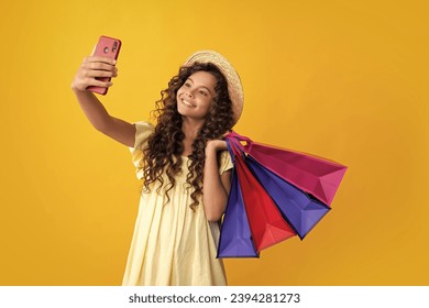 Girl teenager with shopping bags and mobile phone isolated on yellow backgound. Shopping and sale concept. Happy teenager, positive and smiling emotions of teen girl. - Powered by Shutterstock