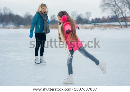 Girl teenager skating with white skates on the ice area in winter day. young Figure skating girl at the frozen lake in the winter. Weekends activities outdoor in cold sunny weather.