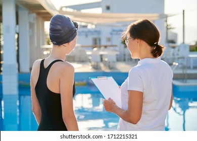 Girl teenager swimmer in sports swimsuit cap with woman trainer near outdoor pool, active healthy lifestyle of youth - Powered by Shutterstock