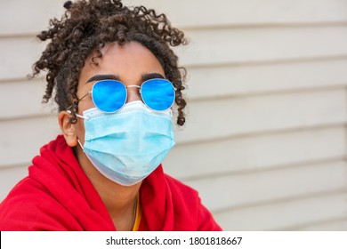 Girl teenager teen mixed race biracial African American female young woman wearing blue sunglasses and face mask in Coronavirus COVID-19 pandemic - Powered by Shutterstock