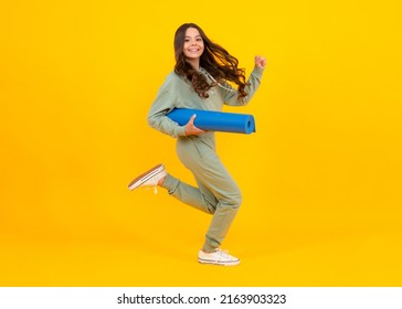 Girl Teenager In Tracksuit. Happy Cute Child In A Yellow Sports Suit On A Yellow Background. Run And Jump. Sportswear Advertising Concept.