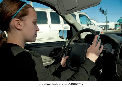 Girl Texting With Cell Phone While Driving, Hand On Steering Wheel