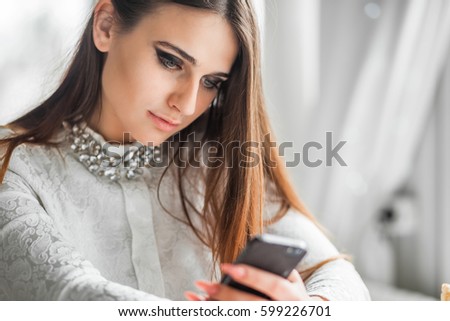 Girl texting on the smart phone in a restaurant 