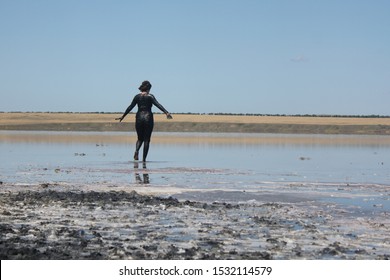 girl in therapeutic mud walking along a salt lake - Shutterstock ID 1532114579