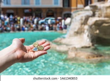 Girl Is Throwing Coin At Trevi Fountain For Good Luck. A Girl Hand Keeping Coin. Trevi Fountain, Rome, Italy. 
