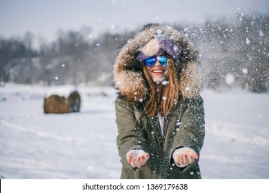 Girl Throwing Snow, Hay Of Bale In Background.