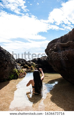 Girl throwing stone into the sea.