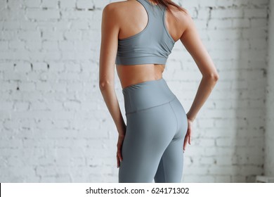 Girl In Tight Clothes Yoga And Fitness Closeup. Gray Leggings With High Waist And Halter Top