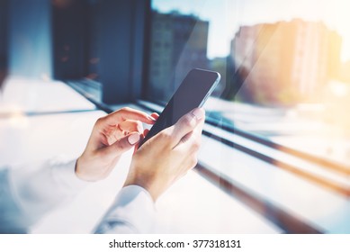 Girl touching a screen of her smarthone. Blurred background, horizontal - Powered by Shutterstock