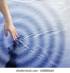 Girl Touching The Water With Ripple Effect.