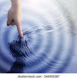 Girl Touching The Water With  With Ripple Effect.