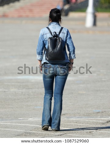 Girl tourist in jeans clothes walking in the city .