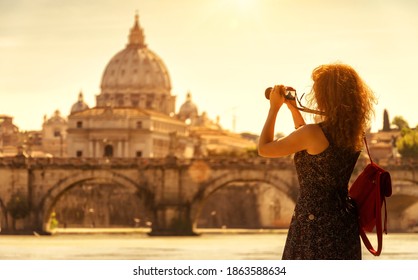 Girl tourist takes photo of St Peter's Basilica, Rome, Italy, Europe. Young pretty woman in Rome on sunny day. Beautiful person photographs Rome attractions. Concept of travel people and sightseeing. - Powered by Shutterstock