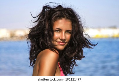 Girl With Tousled Hair On The Beach.