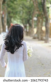 The girl in traditional Vietnamese dress with lily flowers ( Hoa loa Ken ) in April every year in Hanoi, Vietnam