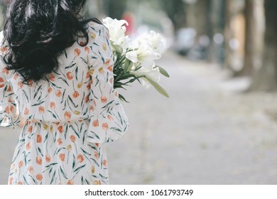 The girl in traditional Vietnamese dress with lily flowers ( Hoa loa Ken ) in April every year in Hanoi, Vietnam