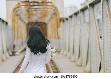 The girl in traditional Vietnamese dress with lily flowers ( Hoa loa Ken ) in April every year in Hanoi, Vietnam