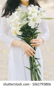 The girl in traditional Vietnamese dress with lily flowers ( Hoa loa Ken ) in April every year in Hanoi, Vietnam